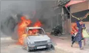  ?? NITIN KANOTRA/HT ?? A woman runs for cover as a car burns nearby after anti-pulwama terror attack protesters went berserk in Jammu.