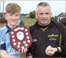  ??  ?? Eoin Staples, the St. Anne’s captain, receives the shield from referee Brendan Martin.