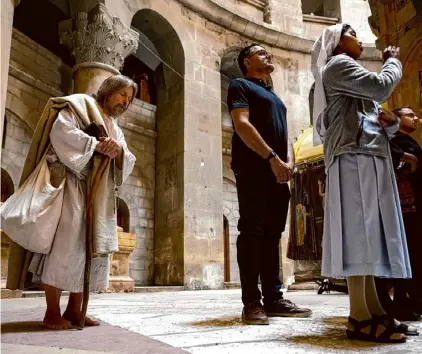  ?? Alexi J. Rosenfeld/getty Images ?? Carl James Joseph, dressed as Jesus, prays at the Church of the Holy Sepulchre on Good Friday in Jerusalem.