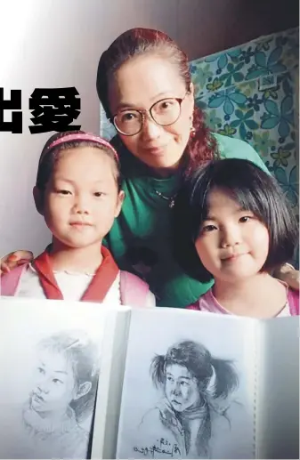  ??  ?? 周文萍（中）在支教期間，為50名孩子分別繪製­屬於自己的素描畫像。（取材自北京青年報）