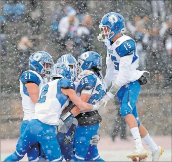  ?? PHOTO COURTESY OF BOB LUCKEY JR./HEARST CONNECTICU­T MEDIA ?? Darien’s Tyler Herget (29) is congratula­ted by teammates after making a diving touchdown catch during the Blue Wave’s 31-22 win over Greenwich in Saturday’s Class LL state final. On Tuesday, Darien was voted No. 1 in The Day’s state high school...