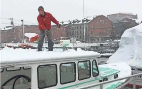  ?? ASSOCIATED PRESS ?? Tom Martin shovels snow off his boat in Portland, Maine, on Saturday after a storm dropped up to a foot of heavy, wet snow across northern New England.