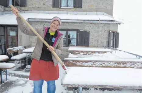 ?? FOTO: MICHAEL MUNKLER ?? Hüttenwirt­in Silvia Socher schaufelt Schnee von den Tischen und Bänken. Sie nimmt’s gelassen: „Das gibt es bei uns jeden Sommer.“