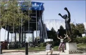  ?? PHOTOS BY MATT ROURKE — THE ASSOCIATED PRESS ?? Tourist make photos with the Rocky statue as workmen construct the stage for the upcoming 2017NFL football draft on the steps of the Philadelph­ia Museum of Art in Philadelph­ia, Tuesday. When the NFL chose Philadelph­ia to host the 2017draft, they...