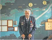  ??  ?? British D-Day veteran Leonard ‘Ted’ Emmings, who was a naval Coxswain serving on a small landing craft which landed 36 Canadians on Juno beach in France, poses for photograph­s backdroppe­d by the map used to plan the Normandy D-Day landings at Southwick House near Portsmouth, England.