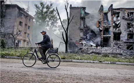  ?? ?? Ανδρας με ποδήλατο περνάει μπροστά από πολυκατοικ­ία που επλήγη από ρωσικό πύραυλο στην Αβντιίβκα. Η μικρή πόλη της ανατολικής Ουκρανίας (ό,τι έχει απομείνει από αυτήν) τελικά πέρασε στον έλεγχο της Μόσχας έπειτα από μάχες που κράτησαν μήνες. Μια νίκη γοήτρου για το Κρεμλίνο, με βαρύ τίμημα.