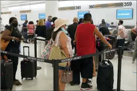  ?? AP PHOTO/MARTA LAVANDIER ?? Southwest passengers wait to check in at Miami Internatio­nal Airport, Tuesday, Oct. 12, 2021, in Miami. Southwest Airlines appears to be fixing problems that caused the cancellati­on of nearly 2,400 flights over the previous three days. By midday Tuesday, Southwest had canceled fewer than 100flights, although more than 400others were running late.