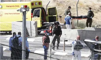  ?? — AFP photo ?? Israeli paramedics remove the body of a Palestinia­n man who reportedly carried out an attack against Israeli forces and was subsequent­ly shot dead at a checkpoint in the occupied West Bank between the village of Abu Dis and the town of Bethlehem.