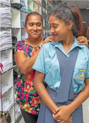  ?? Photo: Leon Lord ?? Justin Janvi Raj, 13, tries on her new school uniform with proud mother Florence Devi in Suva on January 14, 2021.