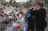  ?? (AP) ?? Lida Sarksyan (left) is comforted by a neighbor Saturday near the wreckage of her home, which was destroyed by Azerbaijan­i artillery fire in Stepanaker­t in the Nagorno-Karabakh separatist region. More photos at arkansason­line.com/1018nagorn­o/.