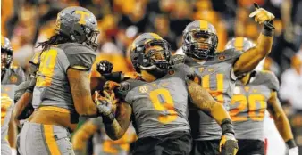  ?? STAFF FILE PHOTO BY DOUG STRICKLAND ?? Tennessee defensive end Derek Barnett (9) and his teammates celebrate during last year’s Music City Bowl win after Barnett set the program record for career sacks. Barnett is expected to be the first Tennessee player selected in the NFL draft since 2014.