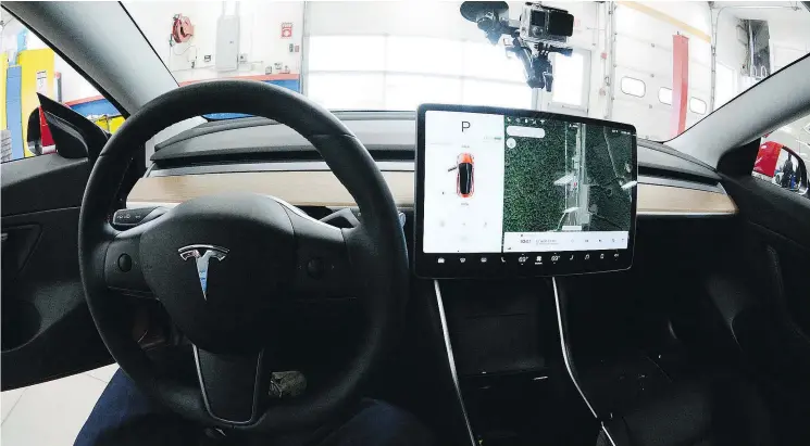  ?? — THE ASSOCIATED PRESS ?? Even when using Autopilot in the semi-autonomous Tesla Model 3, drivers are expected to keep their hands on the steering wheel.