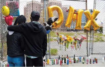  ??  ?? Left: A couple pays their respects at a makeshift memorial for DMX, the hardcore hip-hop star whose ominous, snarling raps chronicled the violence and struggles of the American street, outside White Plains Hospital in New York. — Photos by AFP