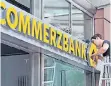  ?? FOTO: DPA ?? Ein Techniker schraubt an einem Schild der Commerzban­k.
