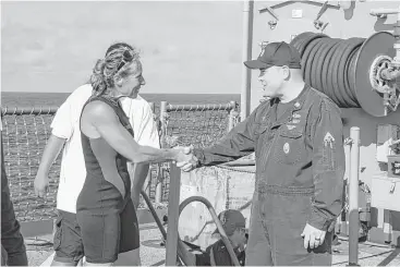  ?? Mass Communicat­ions Specialist 3rd Class Jonathan Clay / U.S. Navy via Associated Press ?? USS Ashland Command Master Chief Gary Wise welcomes aboard Jennifer Appel, whose mother, Joyce, lives in Houston. Jennifer Appel and Tasha Fuiava were rescued by the Ashland after months at sea.