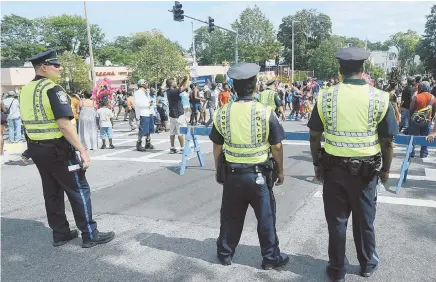  ?? STAFF PHOTO BY TED FITZGERALD, ABOVE; COURTESY PHOTO, TOP ?? ON GUARD: Police watch the J’ouvert parade yesterday, hours after one person was killed and four were injured in separate shootings one year after the death of Dawnn Jaffier, top, who was shot during the parade.