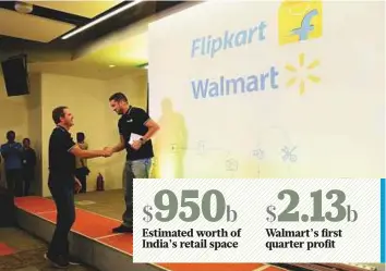  ?? AFP ?? Walmart CEO Doug McMillon (left) and Flipkart co-founder and CEO Binny Bansal shaking hands at an event in Bengaluru, as a deal was announced for Walmart to buy a stake in Flipkart.