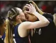  ?? Tyler Sizemore / Hearst Connecticu­t Media ?? UConn’s Paige Bueckers, left, kisses teammate Dorka Juhasz on the forehead after Juhasz was injured in the Huskies’ double-overtime win against NC State in an Elite Eight game March 28.