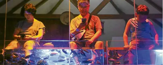  ?? LYN RILLON ?? RESORT EXPERIENCE Asian tourists try a fish spa in Boracay weeks before its closure on April 26.—