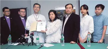  ?? PIC BY KHAIRUL AZHAR AHMAD ?? Pastor Raymond Koh’s wife, Susanna Koh (centre), presenting Suhakam’s findings to Christian Federation of Malaysia chairman Archbishop Julian Leow Beng Kim (third from left) at the Council of Churches Malaysia building in Petaling Jaya yesterday. With them are Koh’s daughter, Esther Koh Sze Ern (second from right), and son, Jonathan Koh (right).