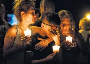  ??  ?? Mona Rodriguez holds her 12-yearold son, J Anthony Hernandez, during a candleligh­t vigil for the victims of the shooting at the First Baptist Church of Sutherland Springs in Texas