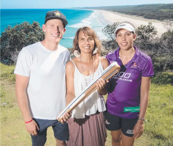  ??  ?? Surfer Bede Durbidge, artist Delvene Cockatoo-Collins and Firebirds netballer Jemma Mi Mi with the Queen’s Baton at Point Lookout at North Stradbroke Island.