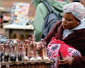  ?? (Courtesy of world bank) ?? A picture of an African woman selling wood sculptures at the local tourist street market in the city of Mbabane.