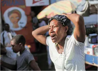  ?? /Reuters ?? Street horror:
A woman reacts at a crime scene where the bodies of several people, who were shot dead amid an escalation in gang violence, were being removed by an ambulance in Port-auPrince, Haiti, on Tuesday.