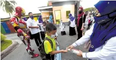  ??  ?? The pupils of Sekolah Kebangsaan Dato Wan Kemara, Changlun, Kubang Pasu were welcomed by Iron Man on their first day of school yesterday.-Bernama photo