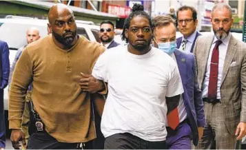  ?? MARY ALTAFFER AP ?? Andrew Abdullah, the man wanted in an apparently unprovoked fatal shooting aboard a New York City subway train, is escorted into a police station Tuesday after he surrendere­d to police.