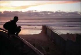  ?? GREGORY BULL — THE ASSOCIATED PRESS ?? A man looks towards where the border wall meets the Pacific Ocean in Tijuana, Mexico, on Wednesday.