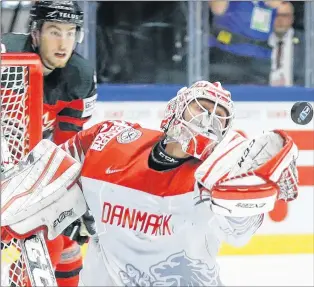  ?? AP PHOTO ?? Canada’s Pierre-luc Dubois watches Denmark’s Sebastian Dahm make a save during world hockey championsh­ip action Monday in Herning, Denmark.