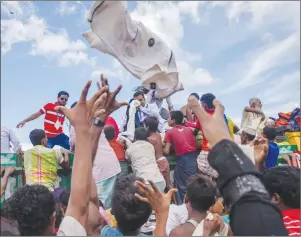  ?? AP PHOTO ?? Rohingya Muslim children, who recently crossed over from Myanmar into Bangladesh, reach out to catch clothes thrown toward them by locals near Balukhali refugee camp in Bangladesh.