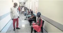  ?? SHIRAAZ MOHAMED THE ASSOCIATED PRESS ?? A hospital worker ensures people are physically distanced as they await their vaccinatio­ns Wednesday in Johannesbu­rg.