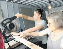  ?? PHOTO: REUTERS ?? Be prepared . . . Jean O’Neill and her daughter Ceri Godinez measure and cut wood to board up their house in Hanalei, on Kauai, Hawaii, yesterday.