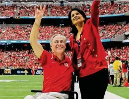  ?? Icon Sportswire via Getty Images ?? Gov. Greg Abbott joins University of Houston Chancellor Renu Khator at a football game. The Legislatur­e gave UH and other schools $3.9 billion.