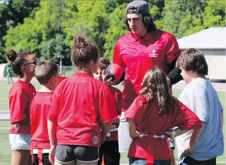  ?? PHOTOS: SHANNON COULTER ?? Luke Willson gathers his team for a group huddle during a recent Jumpstart Games flag football match in London.