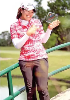  ??  ?? CHAMPION. Thai Supakchaya Pattaranak­rueang hoists her trophy after nailing her first LPGT victory