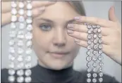  ?? MARTIAL TREZZIN — KEYSTONE VIA AP ?? A Christie’s employee displays a just-sold pair of diamond bracelets with approximat­ely 140 to 150 carats and owned by Queen Marie Antoinette of France.