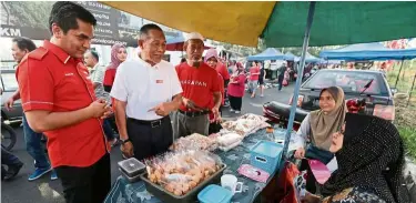  ??  ?? Friendly conversati­on: Karmaine (second from left) and deputy economic affairs minister dr mohd radzi md Jidin chatting with vendors at a market in serkat Laut, Pontian. — bernama