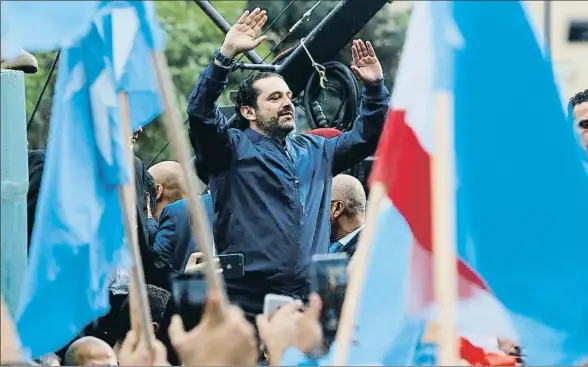  ?? MARWAN TAHTAH / AFP ?? El primer ministro libanés, Saad Hariri, saluda a sus seguidores, con banderas azules de su partido, a su llegada a Beirut