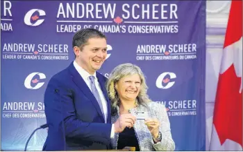  ?? CP PHOTO ?? New Conservati­ve MP Leona Alleslev is presented with a party card by Conservati­ve Leader Andrew Scheer as she is welcomed during the conservati­ve caucus meeting on Parliament Hill in Ottawa on Wednesday.
