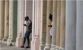  ?? Photograph: Eliana Aponte/AP ?? Cubans use their phones near to where a pre-paid public wifi connection was working near the Malecon seawall in Havana, earlier this month.