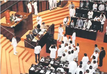  ??  ?? Parliament members argue in front of Jayasuriya during the parliament session in Colombo, Sri Lanka. — Reuters photo