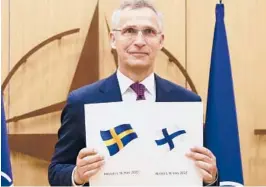  ?? JOHANNA GERON/POOL PHOTO VIA AP ?? NATO Secretary-General Jens Stoltenber­g displays documents as Sweden and Finland applied for membership Wednesday in Brussels, Belgium.