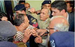  ?? — PTI ?? Security men and officials trying to push away angry protesters who tried to heckle Haryana Chief Minister Manohar Lal Khattar over the Jat agitation in Rohtak on Tuesday.