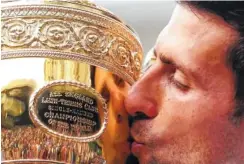  ?? AP PHOTO/LAURENCE GRIFFITHS ?? Novak Djokovic kisses the trophy after defeating Roger Federer in five sets 7-6 (5), 1-6, 7-6 (4), 4-6, 13-12 (3).