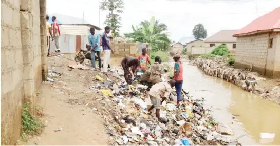  ??  ?? Scavengers search refuse dumped into waterway in Mararaba, Nasarawa State