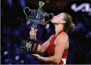 ?? Andy Wong/Associated Press ?? Aryna Sabalenka kisses the Daphne Akhurst Memorial Cup after defeating Zheng Qinwen in the women’s singles final at the Australian Open at Melbourne Park on Saturday.