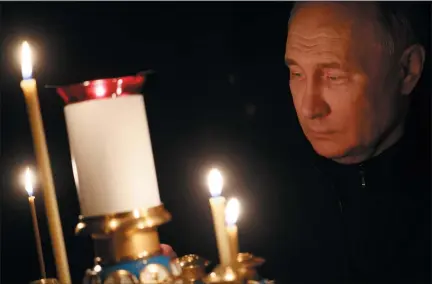  ?? MIKHAIL METZEL, SPUTNIK, KREMLIN POOL PHOTO VIA AP ?? Russian President Vladimir Putin lights a candle to commemorat­e the victims of an attack on the Crocus City Hall concert venue, on the day of nationalmo­urning, in Russia, Sunday, March 24, 2024.